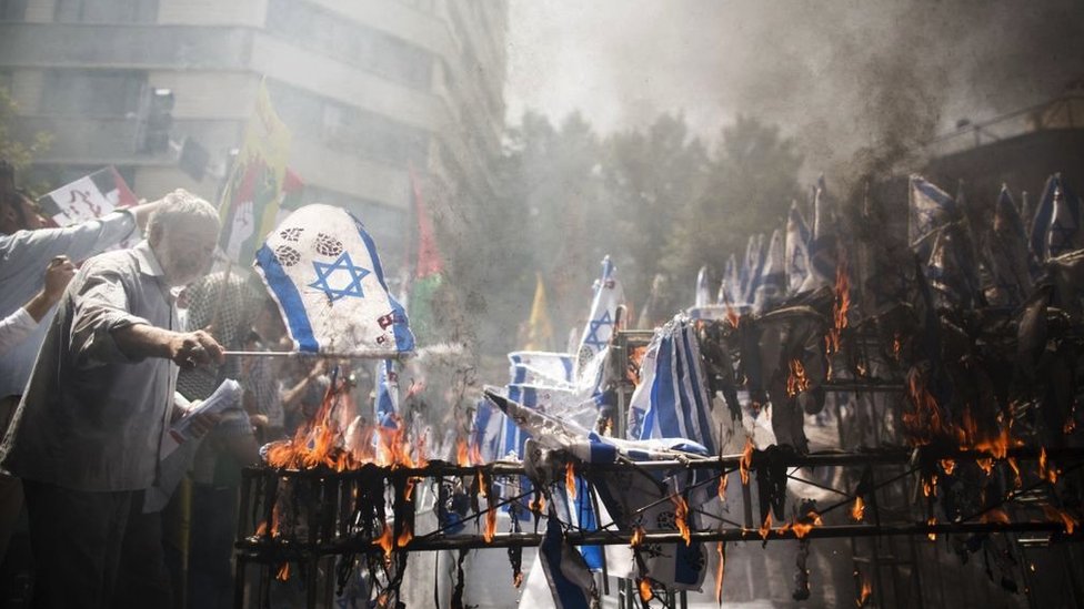 Napad Irana na Izrael: Poreklo rivaliteta i kako ga je rat u Gazi pojačao 4 Men burn Israeli flags at a Tehran demonstration