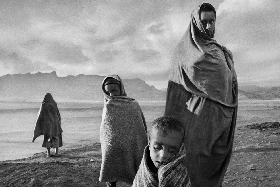 Soni nagrada za fotografiju 2024: Nasilno sterilisane žene sa Grenlanda i tragedija meksičkih starosedelaca 28 Draped in blankets to keep out the cold morning wind, refugees wait outside Korem camp. Ethiopia, 1984