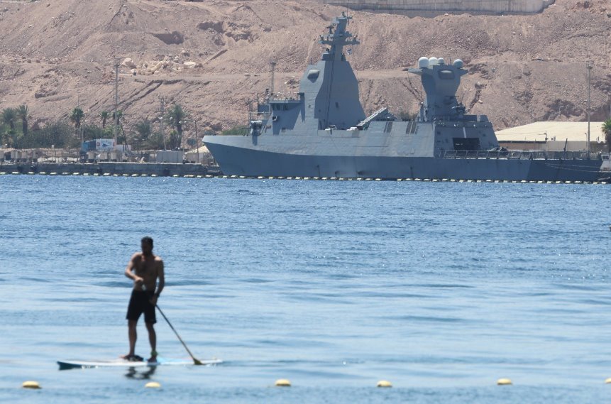 A man paddles in front of a German-made Sa'ar 6-class corvette of the Israeli navy docked at the Red Sea port city of Eilat on 16 April 2024