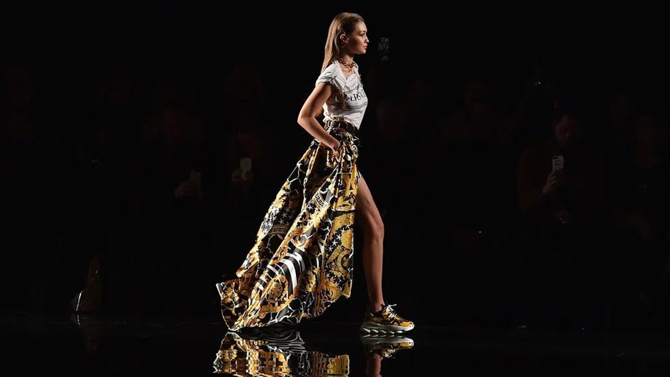 Moda: Da li se visoke potpetice 'kače o klin' 2 Model Điđi Hadid nosi neelegantne patike na pisti tokom modne revije kolekcije Versace Cruise 2019. godine (