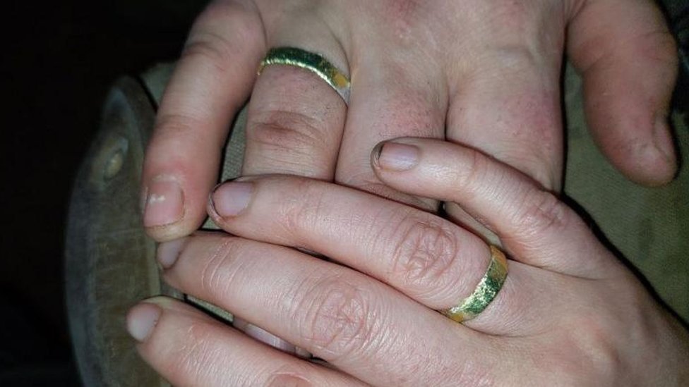 Valeria and Andriy's hands with wedding rings on