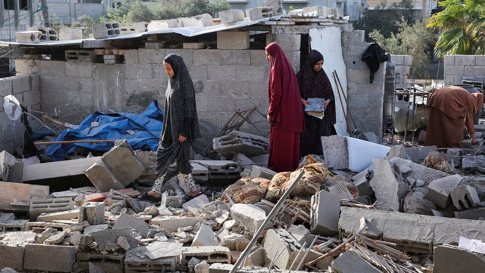 Izrael i Palestinci: Hamas kaže da prihvata sporazum o primirju, čeka se izraelski odgovor 1 Women inspect as a house damaged in an Israeli strike lies in ruin, amid the ongoing conflict between Israel and Hamas, in Rafah