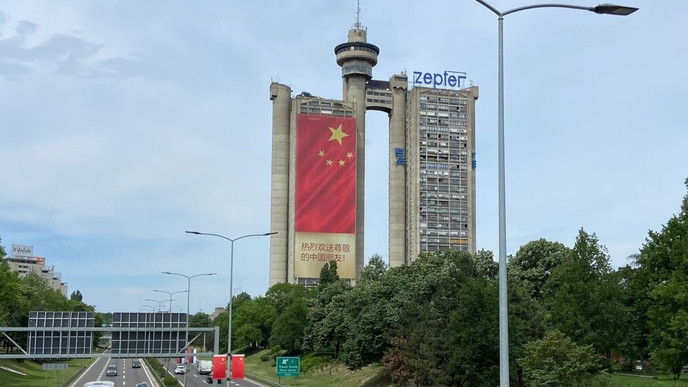 Sa obe strane Geneks kule visi kineska zastava sa porukom dobrodošlice