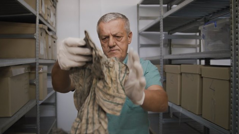 „Ni živ, ni mrtav": Žene sa Kosova već 25 godina tragaju za nestalima 6 Dr Arsim Gerxhaliu examines personal belongings recovered from the mass graves