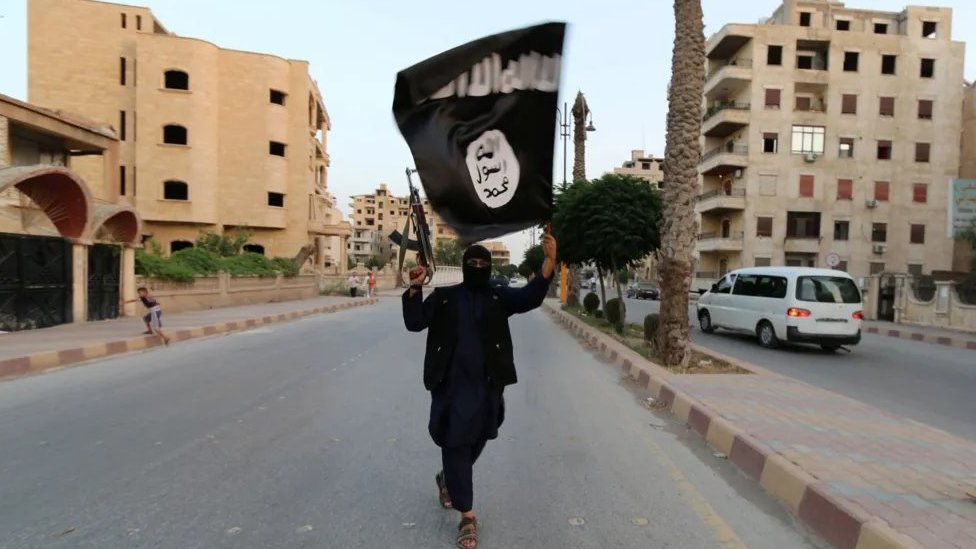 Udovica lidera Islamske države otkriva detalje o zajedničkom životu 6 Naoručani pripadnik Islamske države nosi zastavu u ruci u Raki u junu 2014. godine