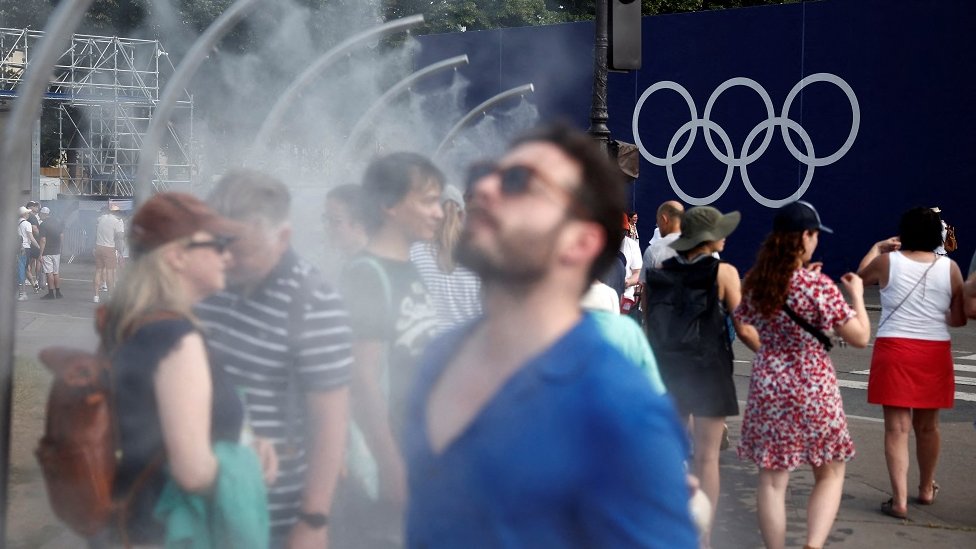 Klimatske promene: Četiri načina na koje se gradovi rashlađuju tokom letnjih vrućina 1 Ljudi se rashlađuju ispod tuševa u Parizu