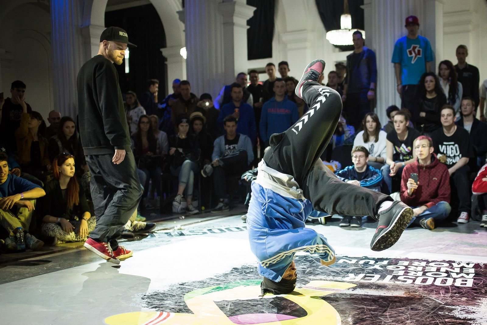 Olimpijske igre u Parizu 2024: Brejking, preko filmova, video kaseta i spotova, do balkanskih ulica 1 Srđan Poštin iz Flortodoksa se vrti na glavi, dok ga posmatra Luka Lukić iz druge beogradske ekipe Rekognajz