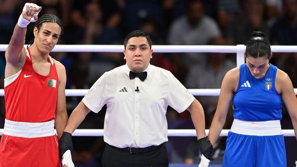 Olimpijske igre u Parizu 2024: Šta nauka kaže o raspravi oko pola dve bokserke 5 Sudija u ringu drži za ruke Iman Helif (levo) u crvenom dresu i Anđelu Karini (desno) u plavom dresu