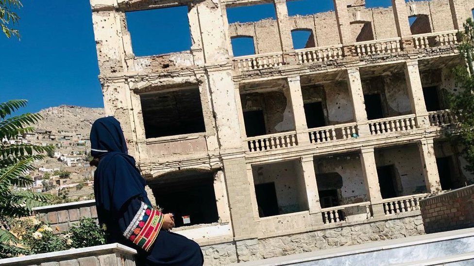 Ženska prava: Obrazovane Avganistanke „sanjaju neostvarene snove“ 1 Avganistanka Nadia iz profila u crnoj garderovi sa vezenim šarenim rukavom gleda u napuštenu zgradu