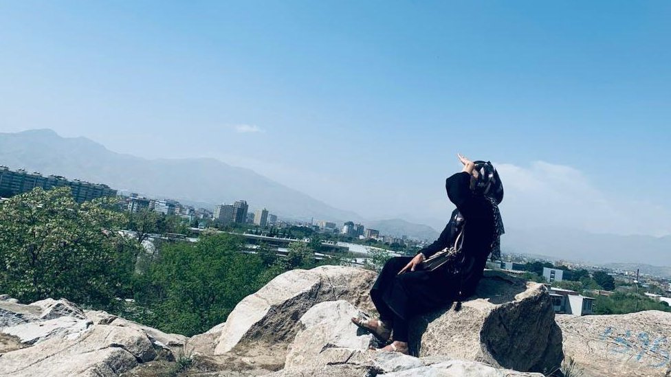 Ženska prava: Obrazovane Avganistanke „sanjaju neostvarene snove“ 2 Avganistanka Nadia sedi u crnoj garderobi na stenama poviše grada