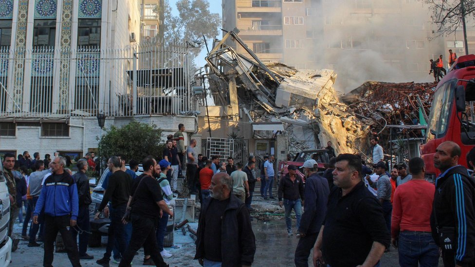 Izrael i Iran: Od rata preko saveznika do mogućeg regionalnog sukoba na Bliskom istoku 4 Ljudi se okupljaju u blizini ruševina iranskog konzulata u glavnom gradu Sirije Damasku 1. aprila 2024.