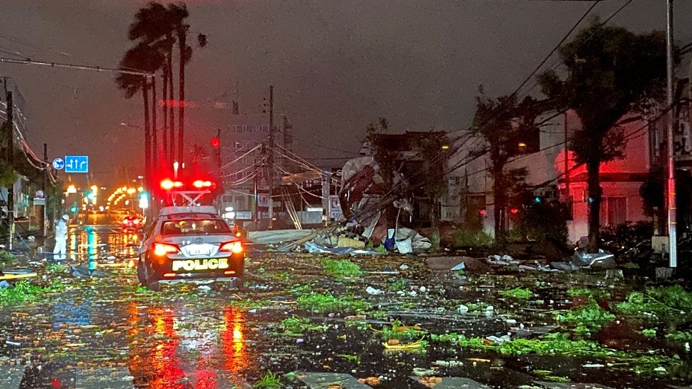 Tajfun pogodio Japan, nastradalo šestoro ljudi 3 Posledice tajfuna u Mijazakiju noću, kola policije i cesta prekrivena smećem