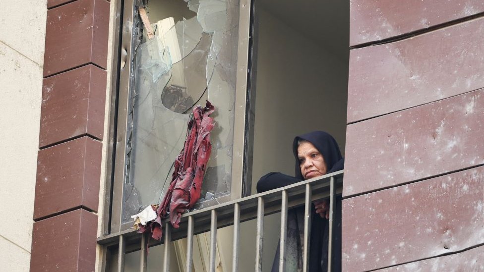 Bliski istok: Strah se širi Bejrutom posle napada u kome je 22 stradalo 1 Žena gleda uništene zgrade kroz polomljen prozor u centru Bejruta