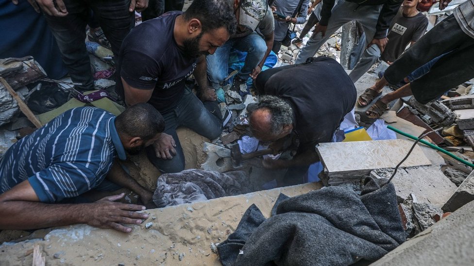 Izrael i Palestinci: Više od 70 mrtvih u napadima na Gazu, nastavljeno bombardovanje Bejruta 2 Ljudi pokušavaju da dođu do preživelih ispod srušenih zgrada u kampu Tal al-Zatar