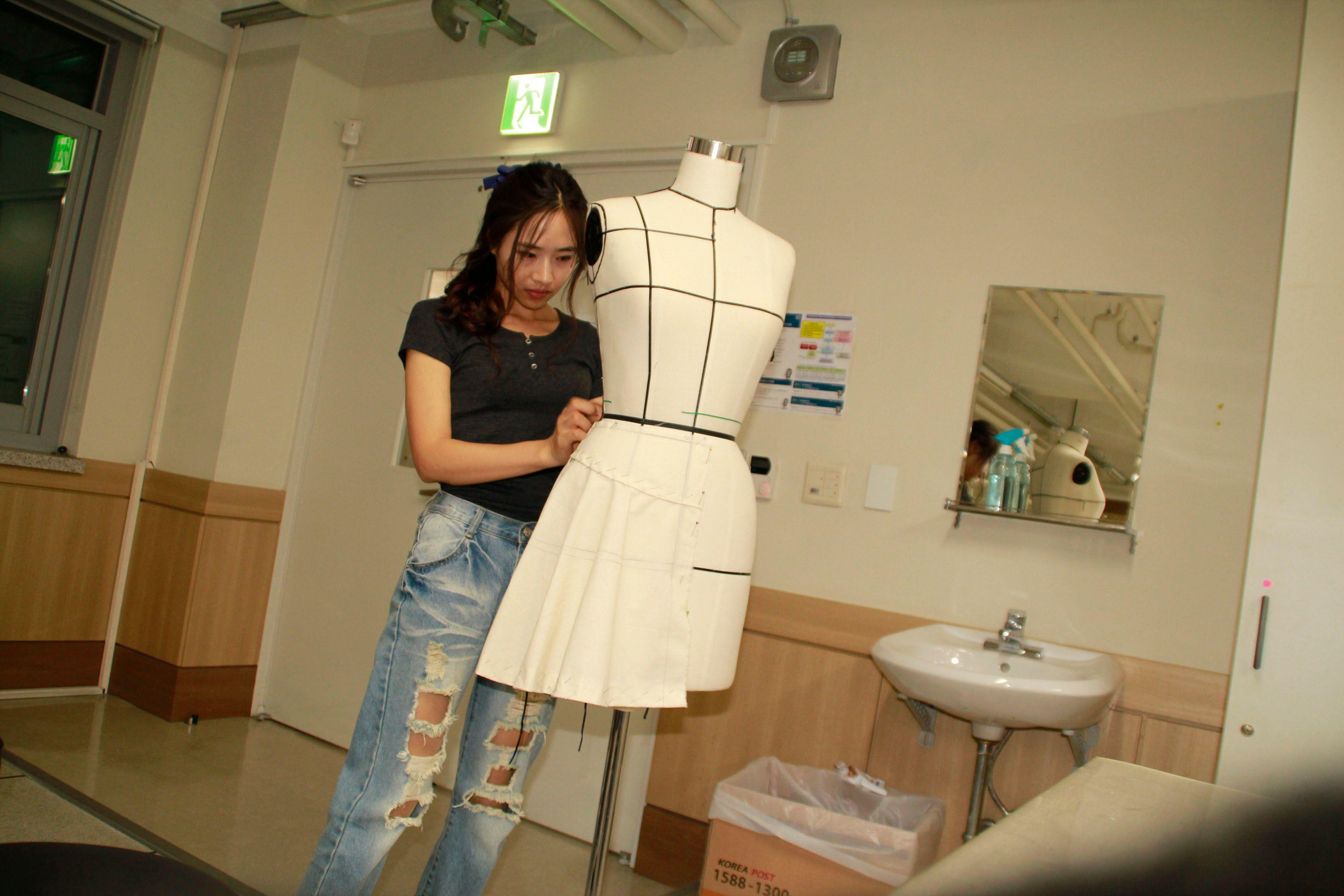 Modna dizajnerka iz Severne Koreje: 'Videla sam slobodu u pocepanim farmerkama' 1 Kang nosi pocepane farmerke dok radi na njenoj kreaciji