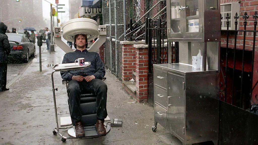 'Večni sjaj besprekornog uma' kao upozorenje za današnje ljubavi i veze 2 Scena iz filma Večni sjaj besprekornog uma - glavni lik je na stolici, na ulici, pred njim je sto sa čašom, na kojoj je lik devojke koju želi da zaboravi