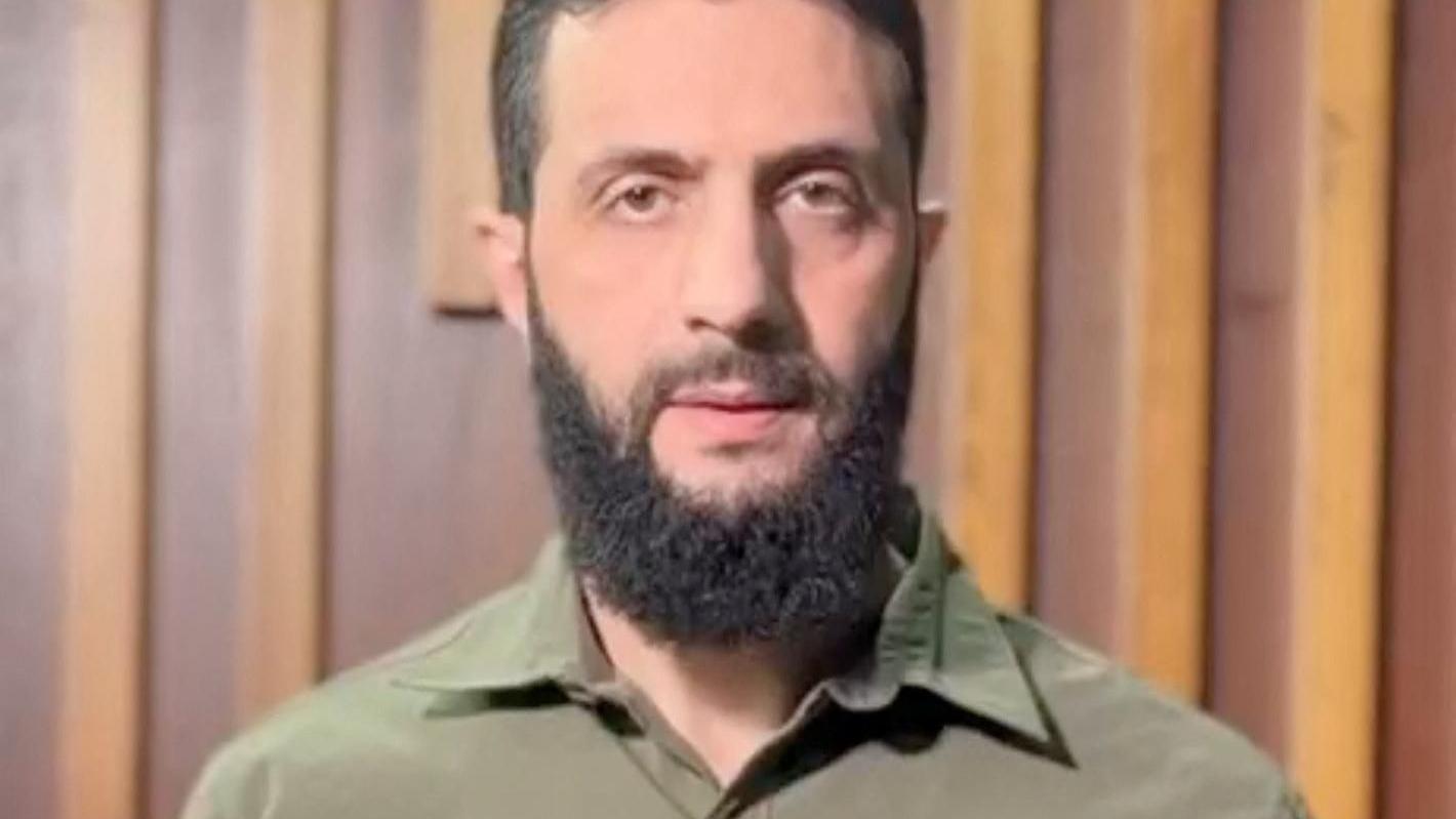 Lider HTS-a nije jedini igrač u budućnosti Sirije koja se ubrzano menja 2 Abu Mohammed al-Jawlani looks directly at the camera in this screenshot of a video. He's dressed in a green military shirt and has a dark beard.