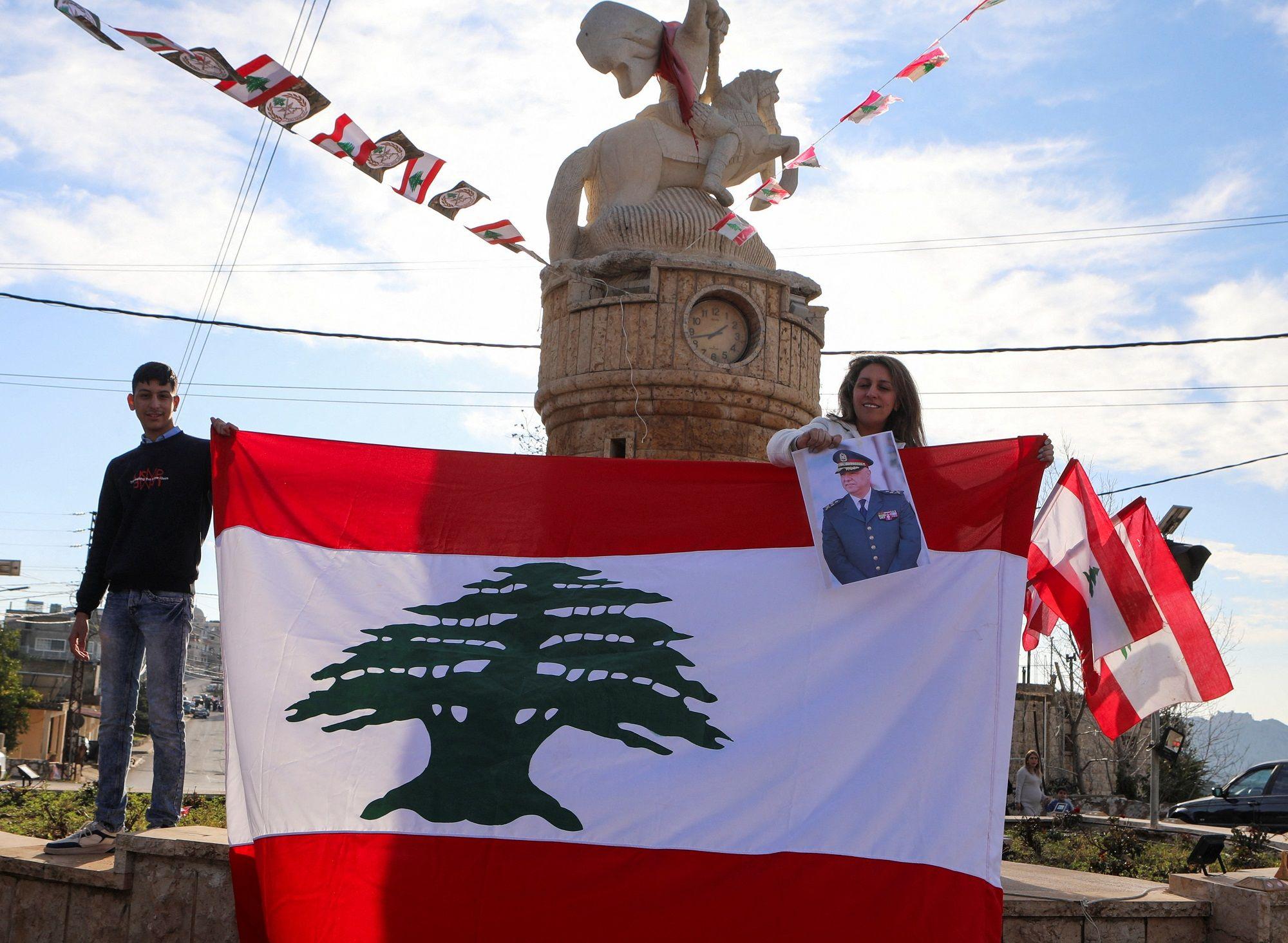 'Nova faza u istoriji Libana': Posle dve godine izabran predsednik 3 Dvoje ljudi drži libansku zastavu između sebe i fotografiju Džozefa Auna
