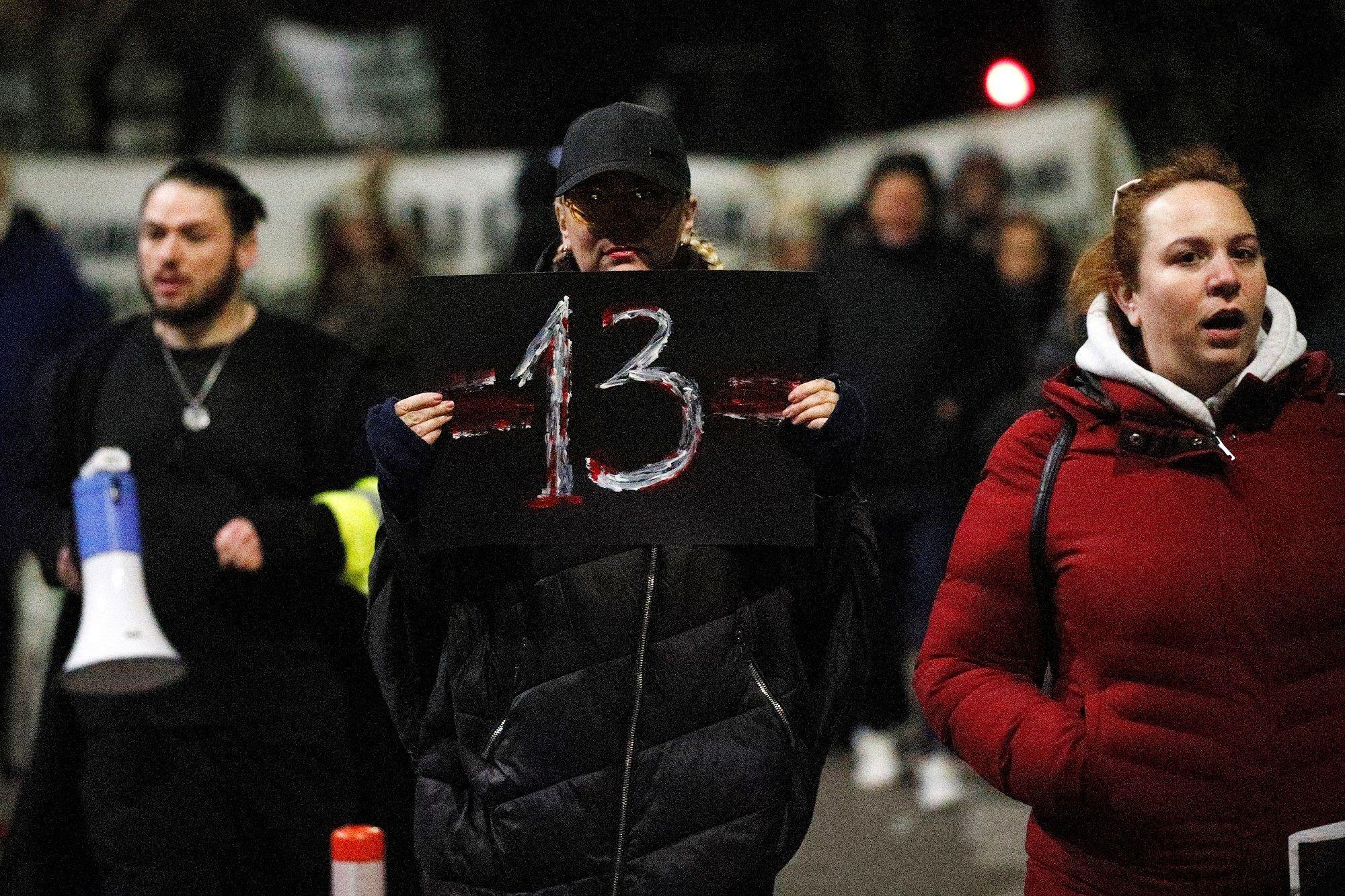 Zahtevi za ostavkama na skupu protiv nasilja u Podgorici 2 Muškarac drži plakat sa brojem 13