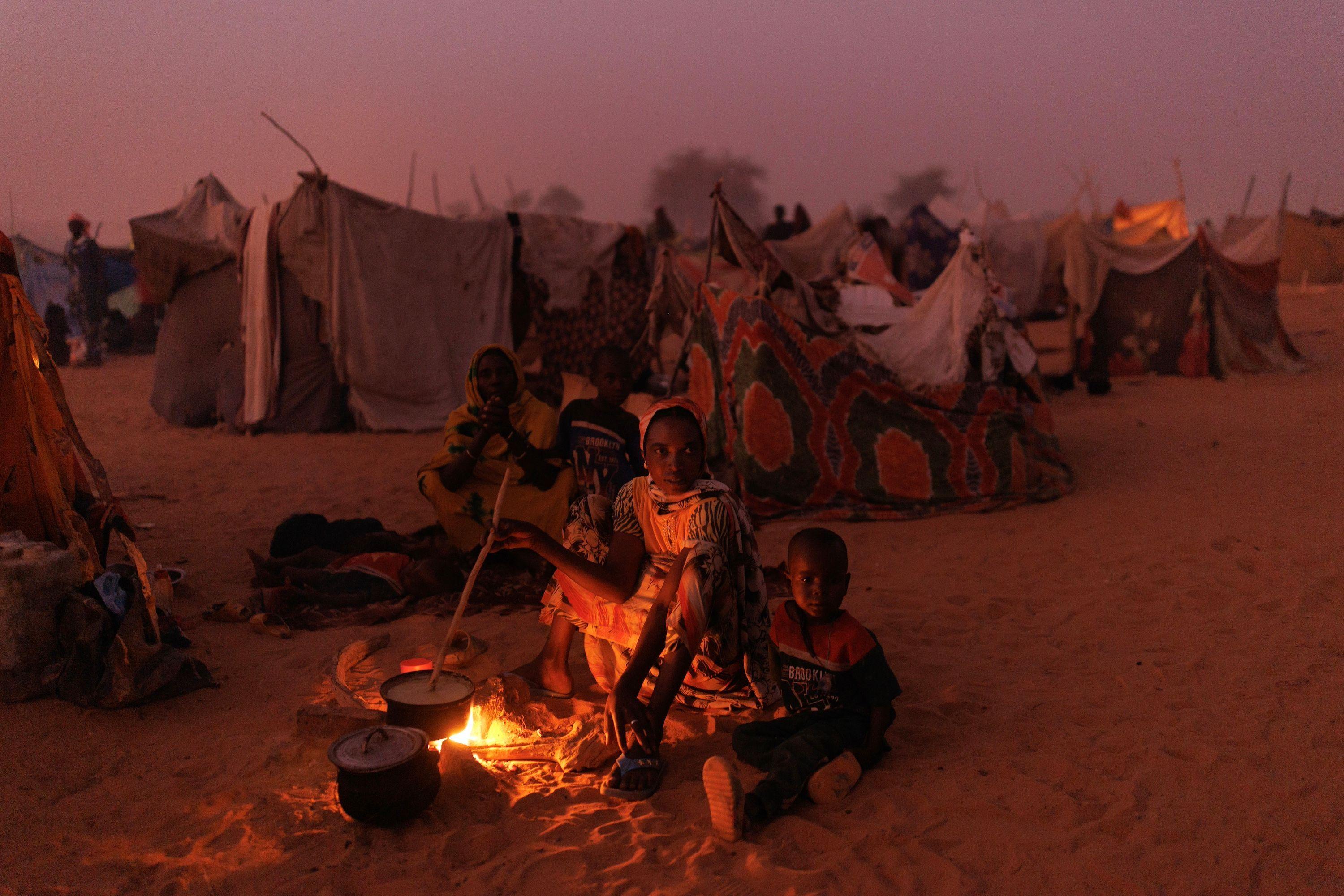 2024: Kako je pamtimo u fotografijama 9 Novopridošle izbeglice iz Sudana u sumrak kuvaju hranu na vatri u privremenom kampu u blizini grada Adra u Čadu, 24. april 2024.