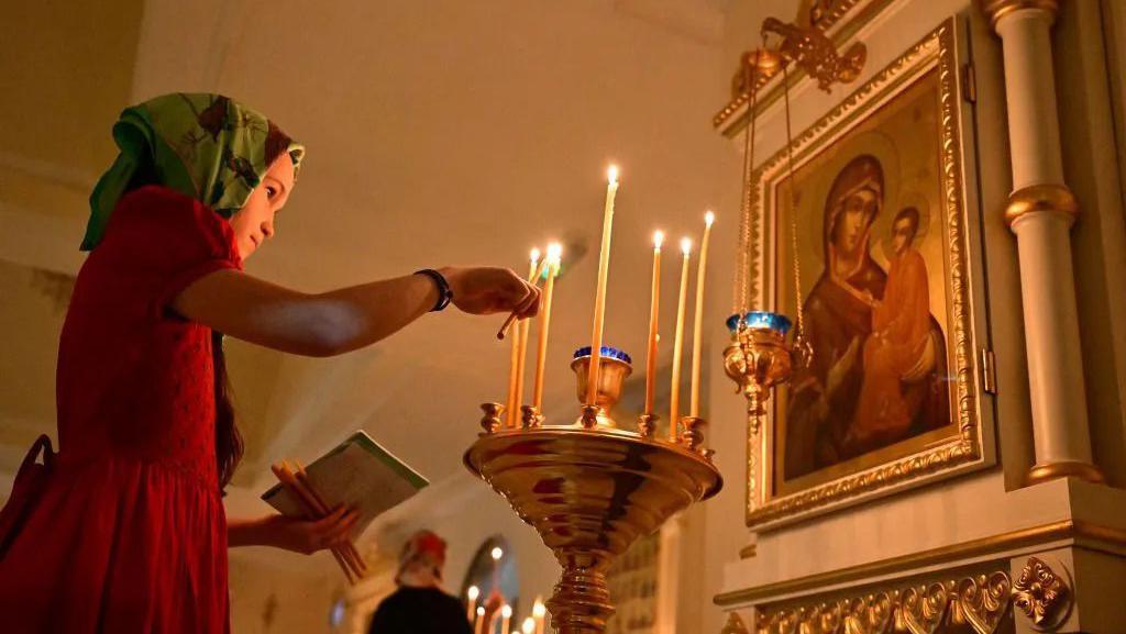 Pravoslavni hrišćani širom sveta slave Božić 3 Devojčica pali sveću u crkvi