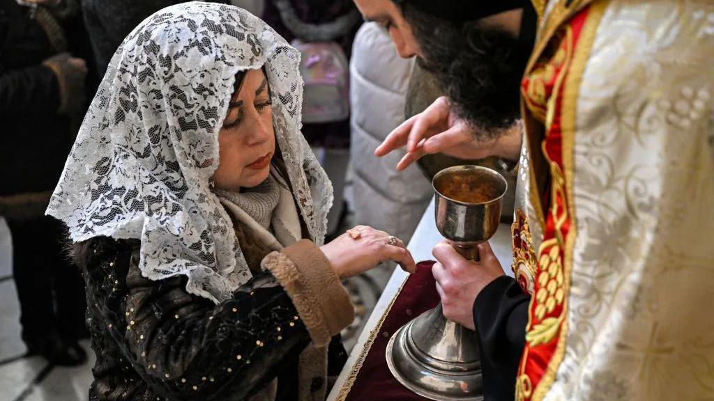 Pravoslavni hrišćani širom sveta slave Božić 1 Žena se pričešćuje u jermenskoj apostolskoj crkvi
