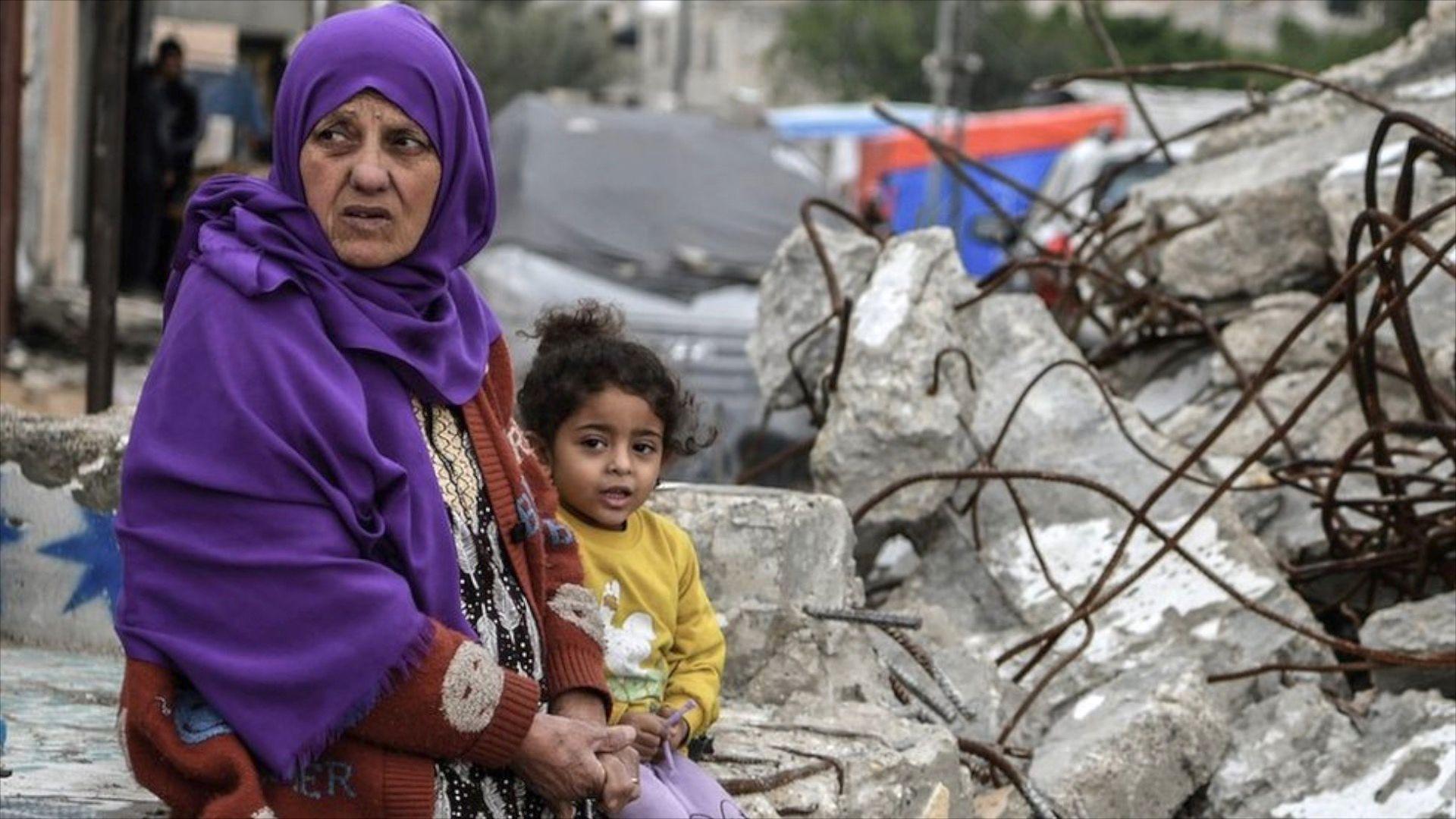 Kako glasi sporazum o primirju u Gazi i može li da potraje 1 Žena sa ljubičastom maramom na glavi i devojčica u žutom džemperu sede na betonskim ruševinama Gaze