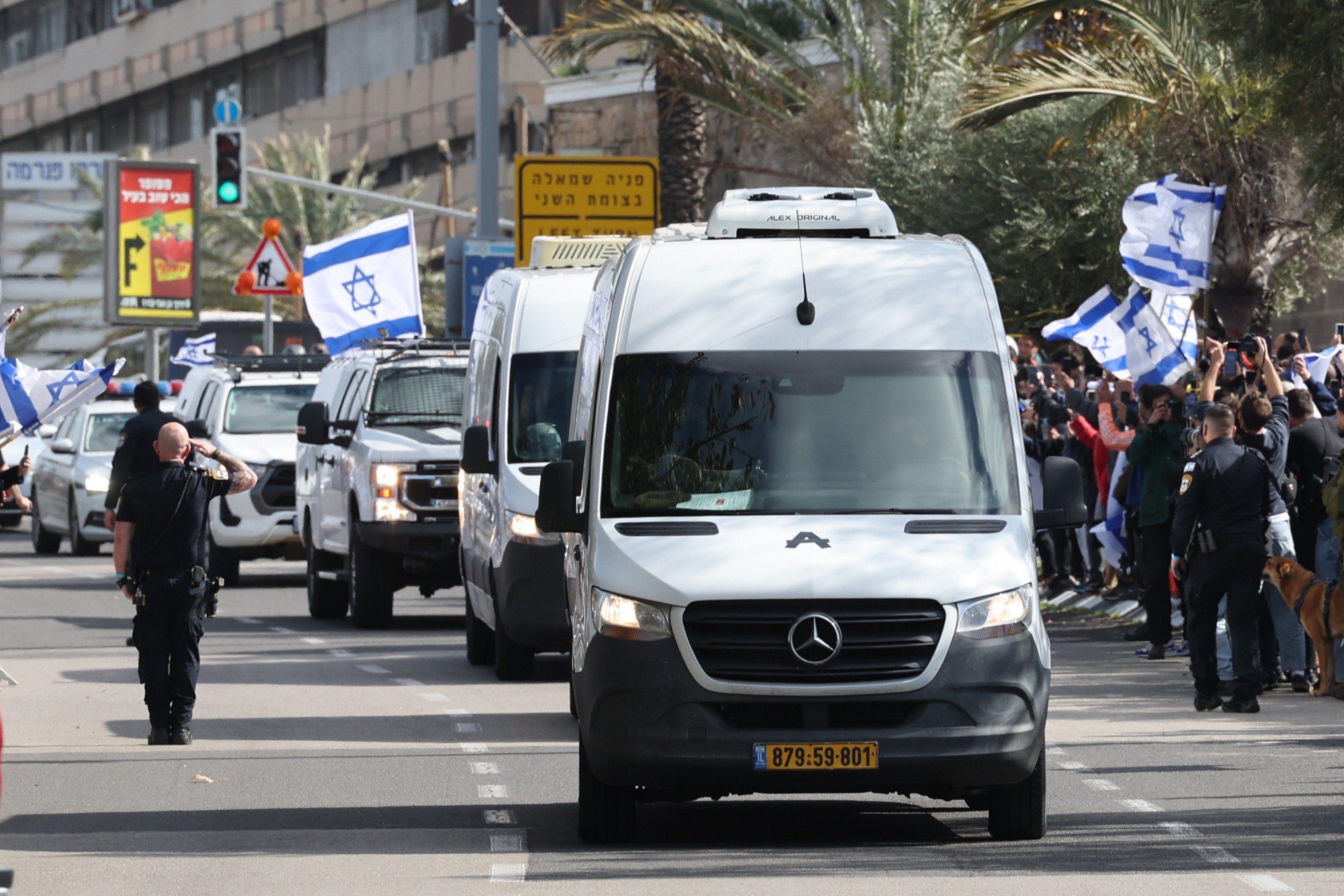 Hamas predao Izraelu tela četvoro talaca 1 Kolona automobila ide ulicom, dok vojnik salutira, a okolo stoje ljudi sa izraelskim zastavama