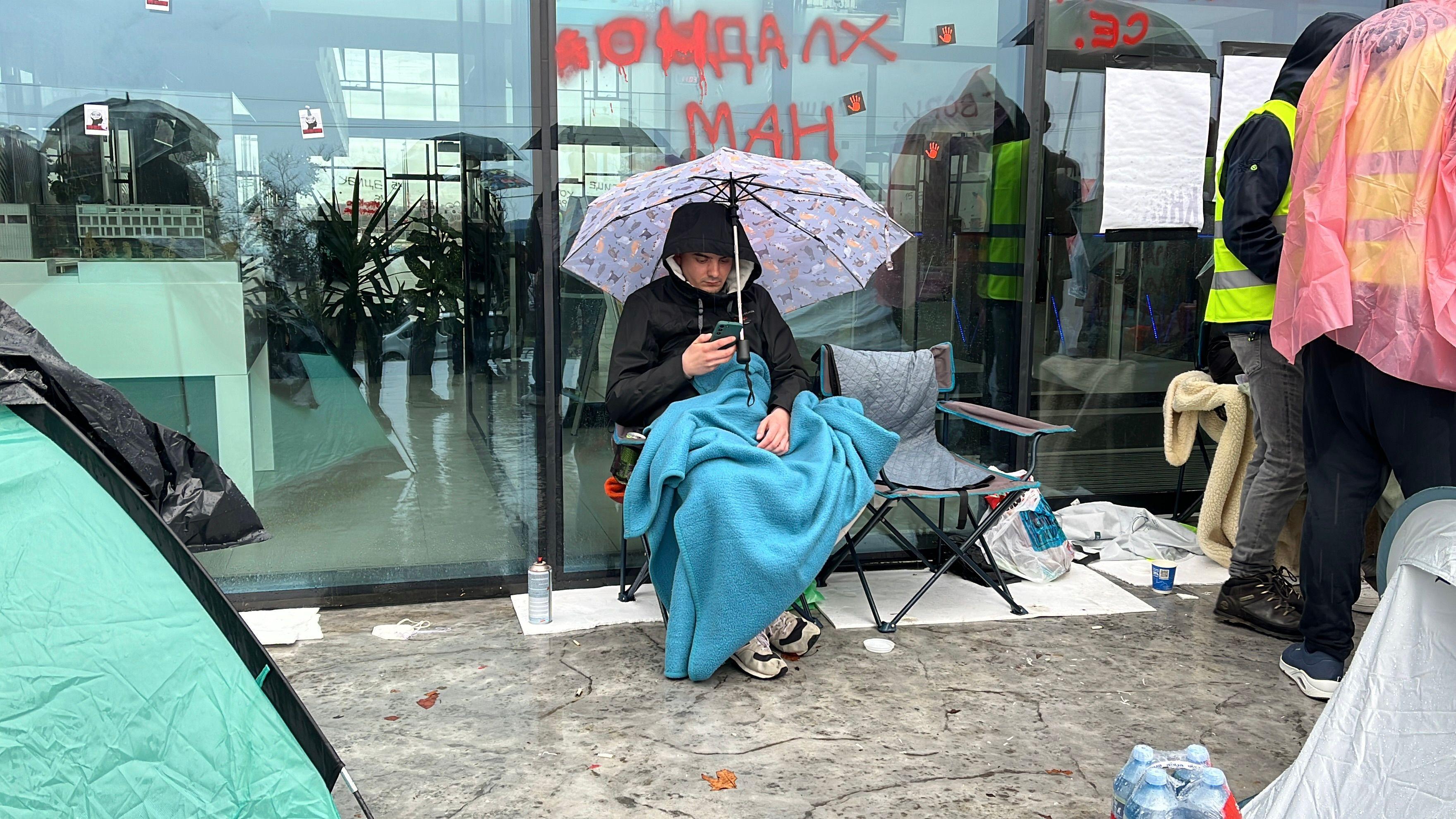 Studenti blokirali zgradu Radio-televizije Srbije, policajcu povređeno oko 6 Student sa kišobranom i ćebetom ispred zgrade RTV-a