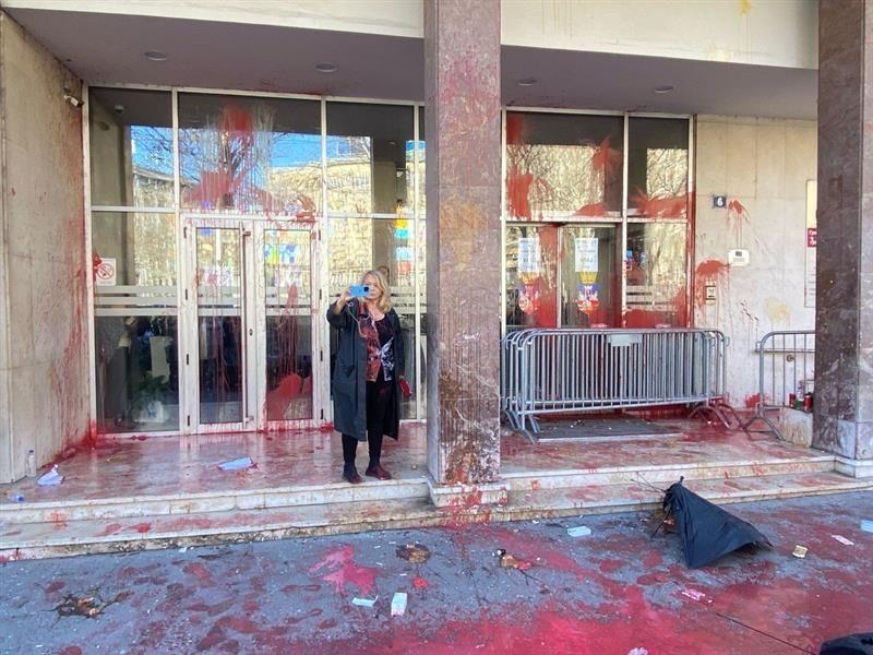 Privođenja i neredi ispred Skupštine Beograda 4 Žena fotografiše, oko nje crvena farba na pločniku ispred zgrade Skupštine Beograda
