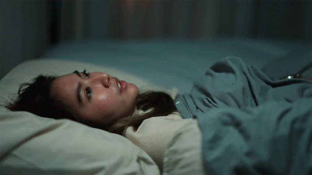 žena leži u krevetu otvorenih očiju 