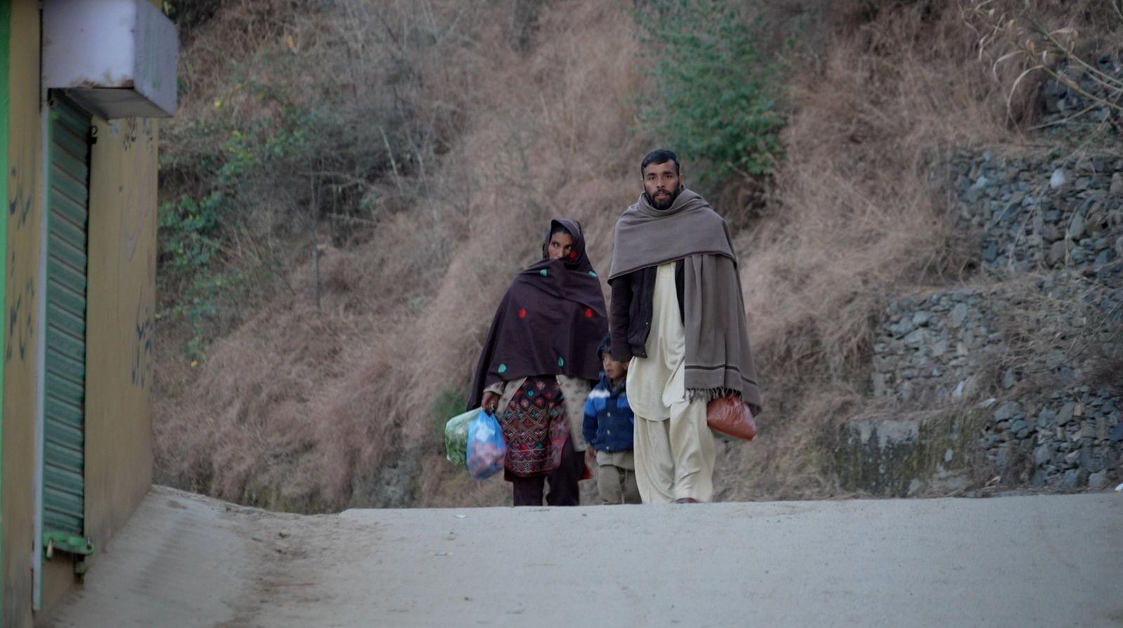 Žena i muškarac hodaju zajedno sa kesama u rukama