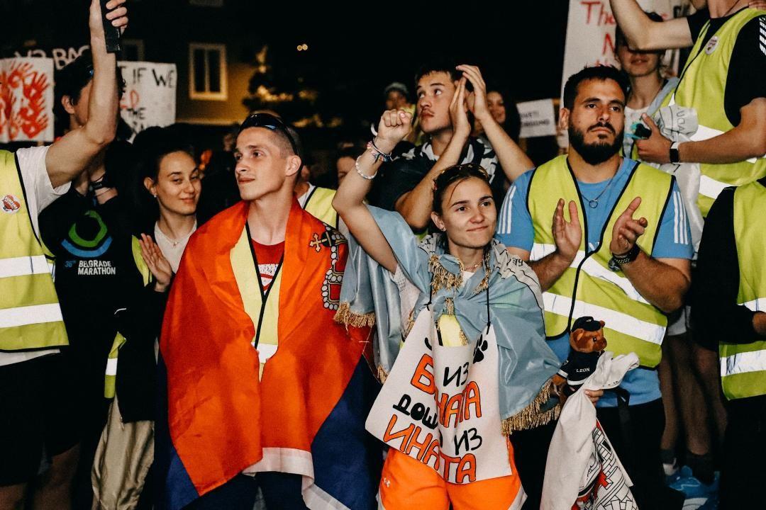 Muškarci i devojke ogrnuti zastavama se vesele