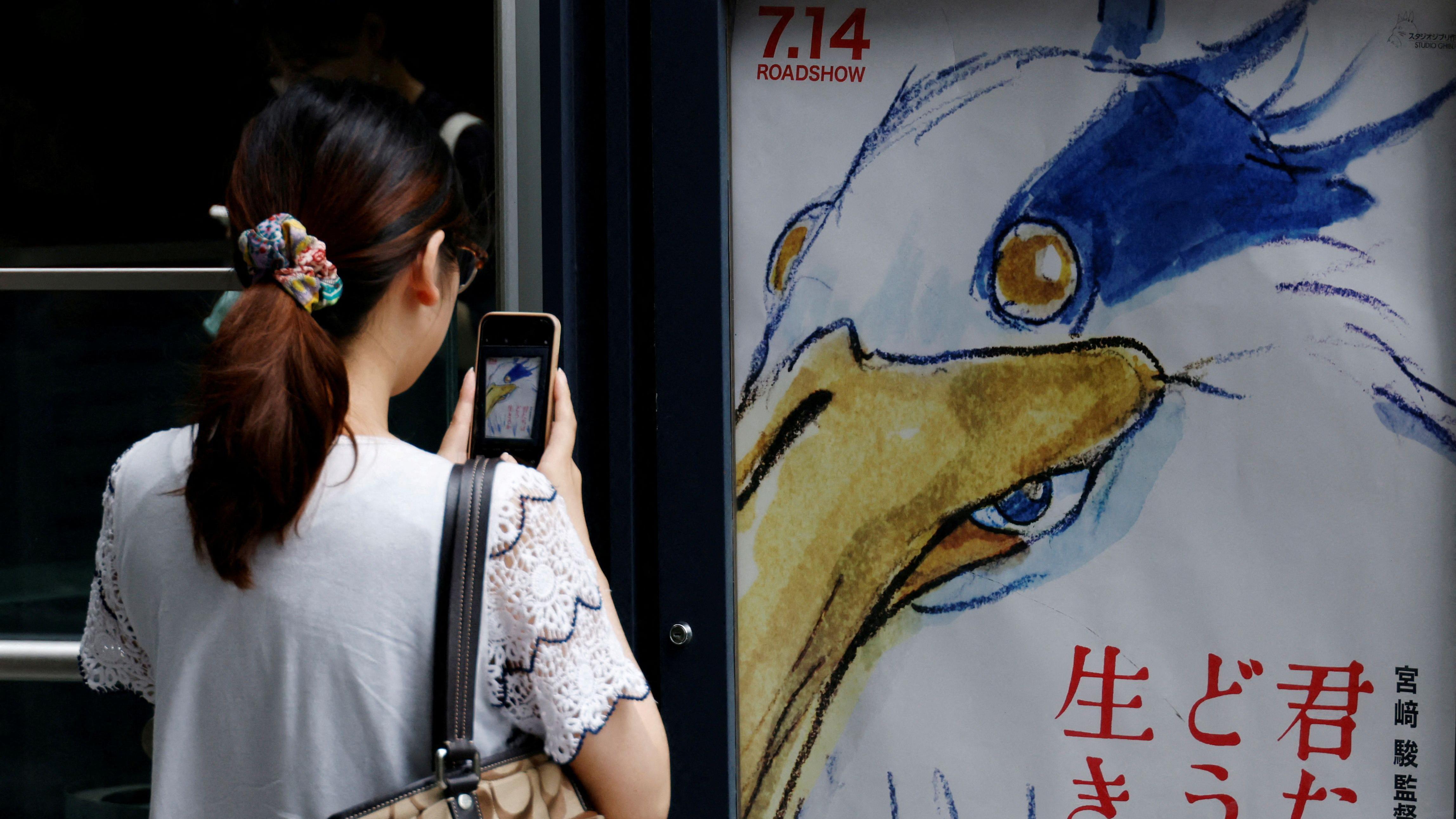 U čemu je magija 'Studija Gibli', kojim je internet opsednut 4 Žena fotografiše poster za film „The Boy and the Heron"