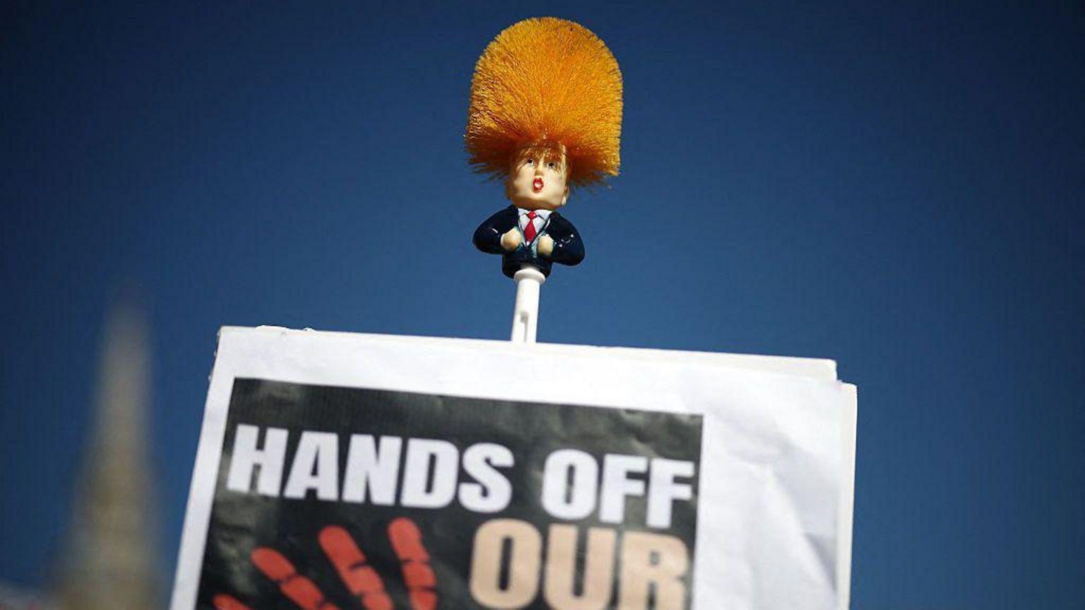 Protesti protiv Trampa širom Amerike 2 četka za WC sa Trampovim likom i natpis dalje ruke