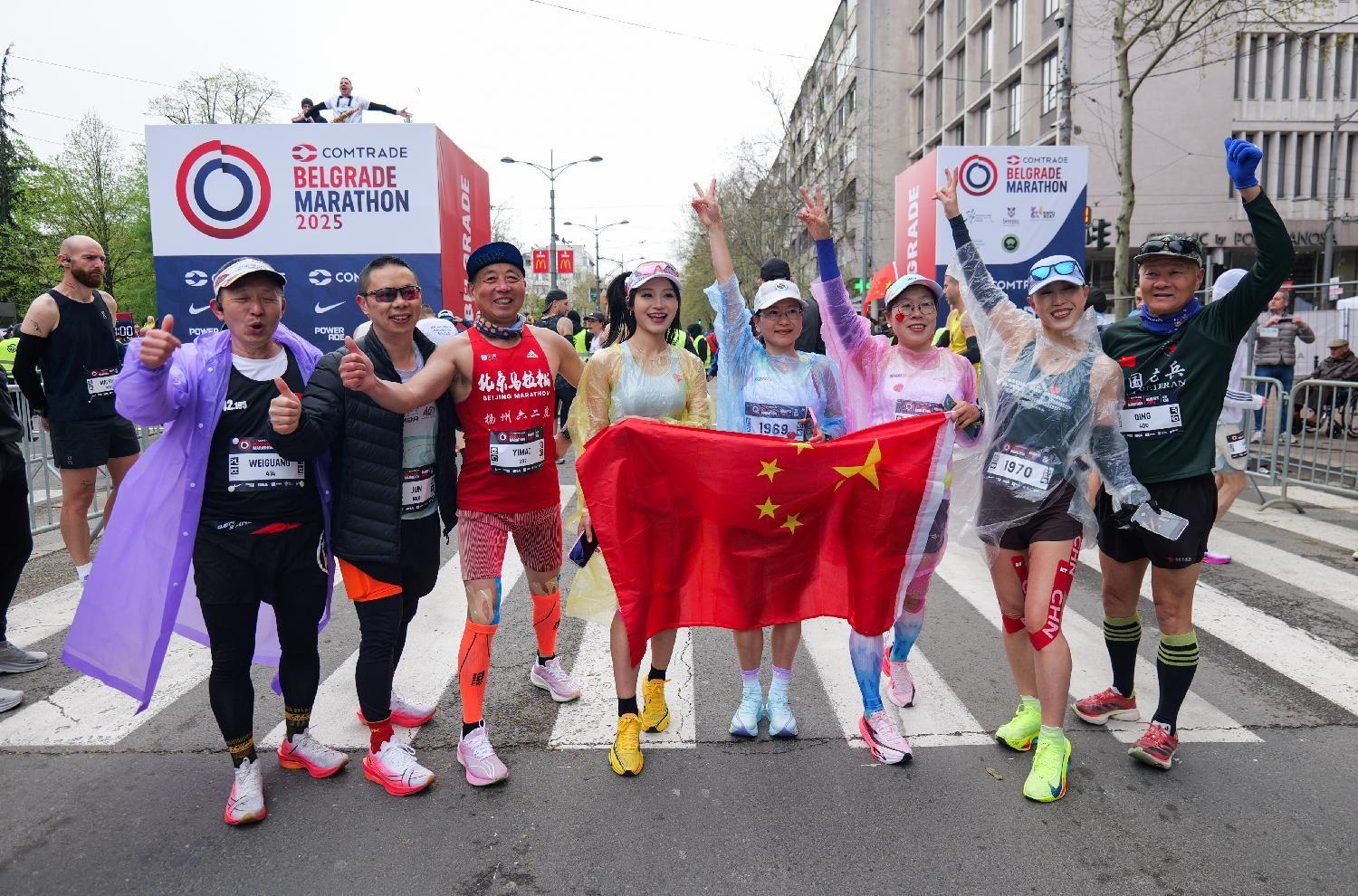Rekordan broj učesnika, susnežica i 'Pumpaj': Beogradski maraton u fotografijama 3 Trkači drže zastavu Kine