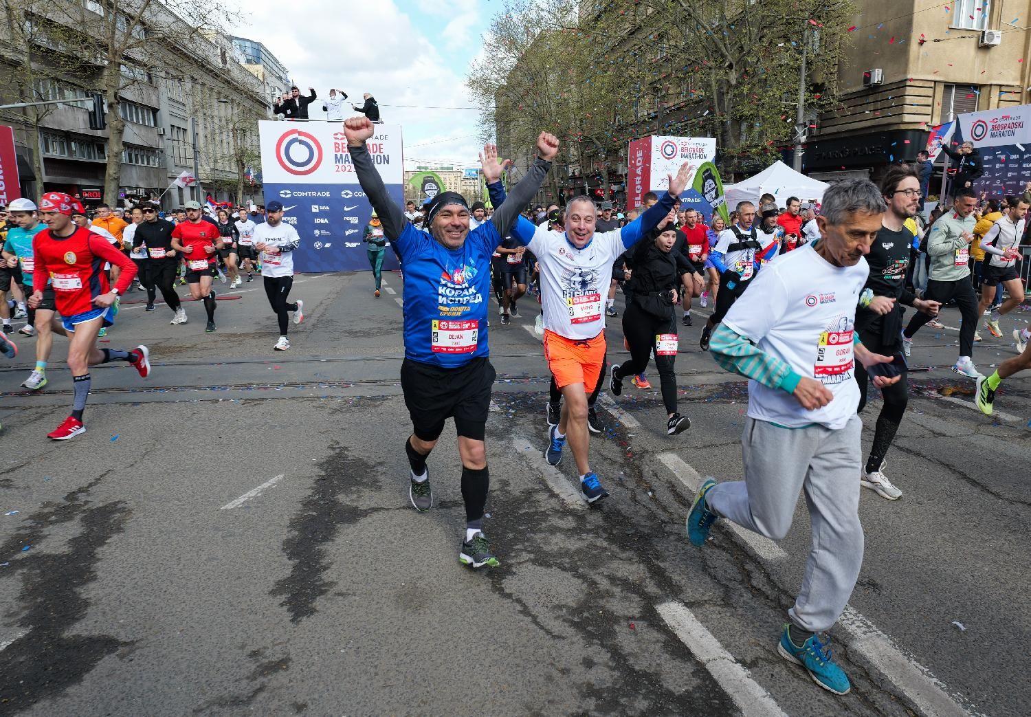 Rekordi, susnežica i 'Pumpaj': Beogradski maraton u fotografijama 9 Ljudi gestikuliraju dignutih ruku na početku maratona