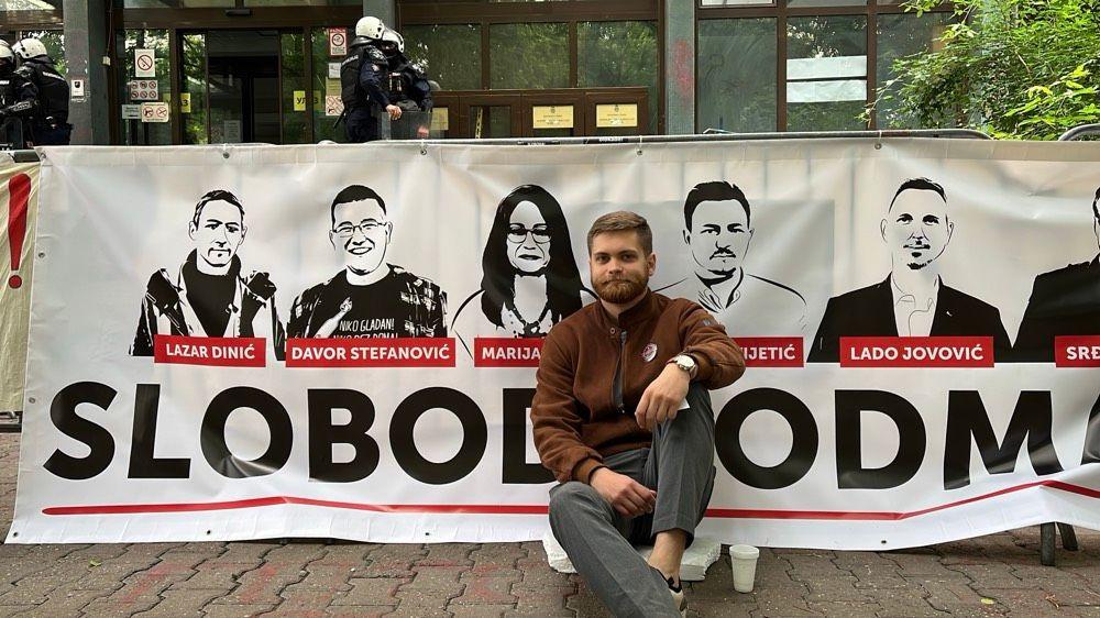 Kućni pritvor za troje aktivista, poruka iz Evrope vlastima: 'Poštujte ljudska prava' 5 Sin Marije Vasić, Milan Čanak, ispred transparenta sa likovima pritvorenih