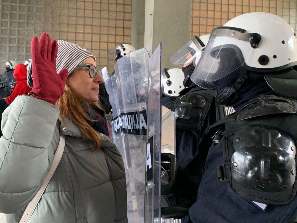 'Novosadska šestorka': Nastavljena blokada suda, stanje Marije Vasić 'bolje' 1 Žena sa podignutim rukama ispred policajca pod punom opremom za razbijanje demonstracija