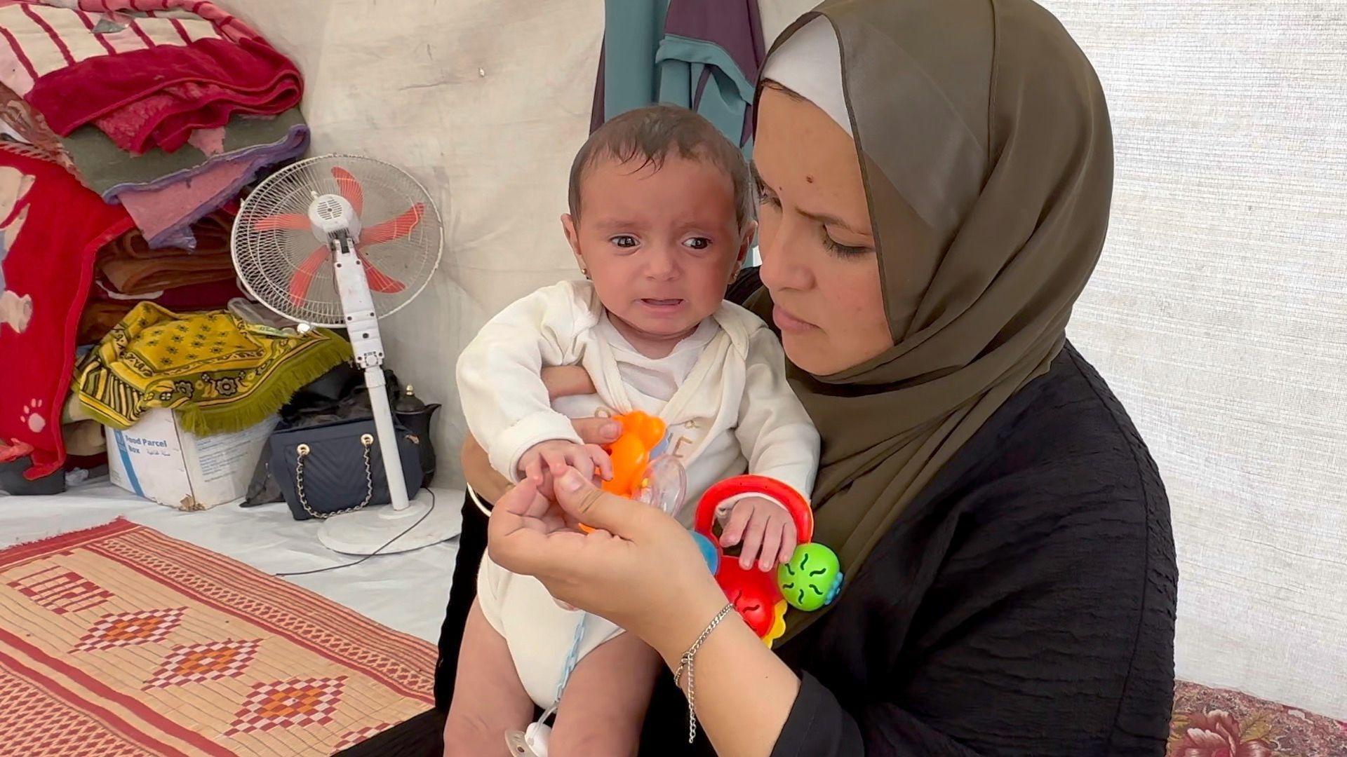 žena drži bebu, beba u gazi, majka i beba u gazi