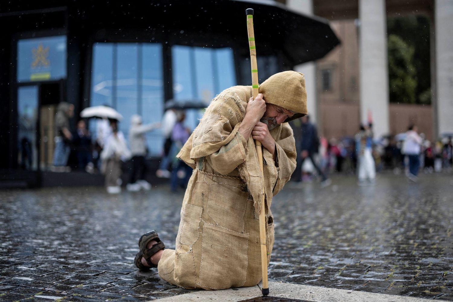 Beli dim u Vatikanu: Izabran novi papa 13 Muškarac kleči i moli se