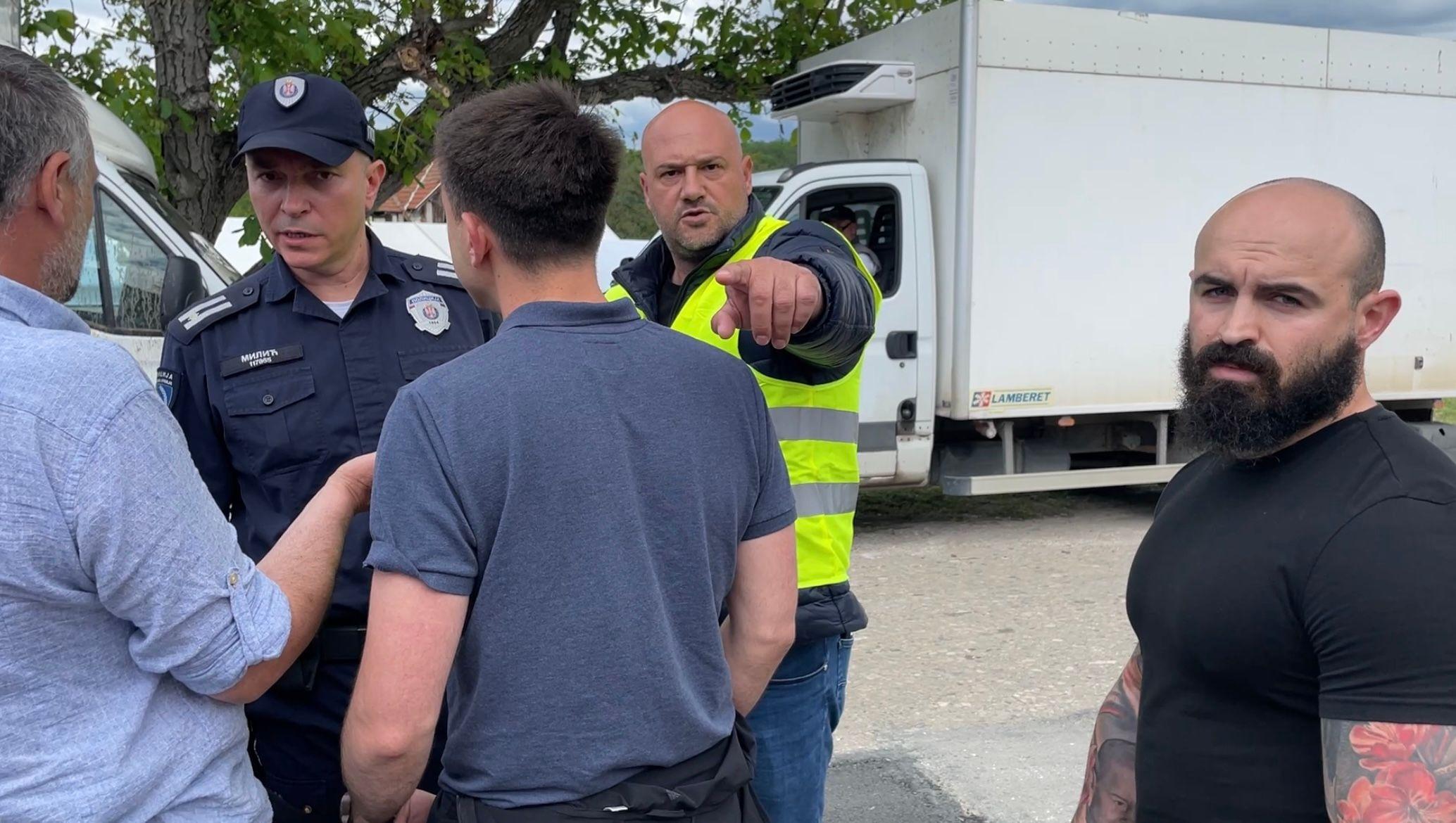 Novinari Miljko Stojanović i Miodrag Sovilj u razgovoru sa policijom dok neidentifikovana lica pokazuju ka BBC kameri