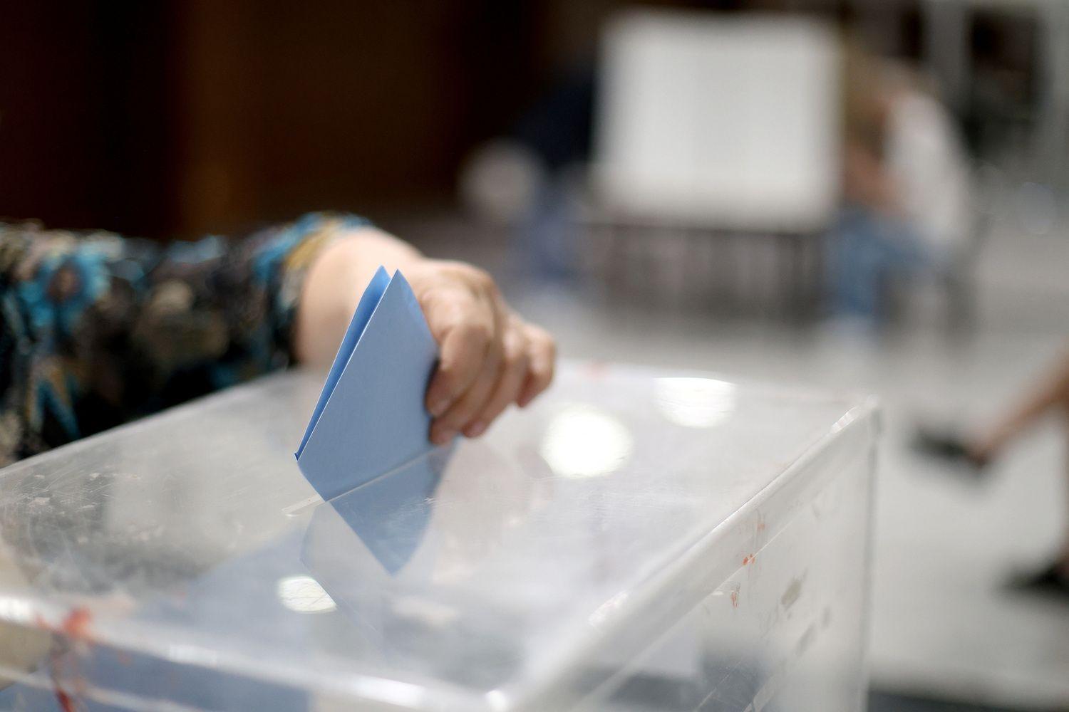 Ruka koja ubacuje glasački listić u kutiju