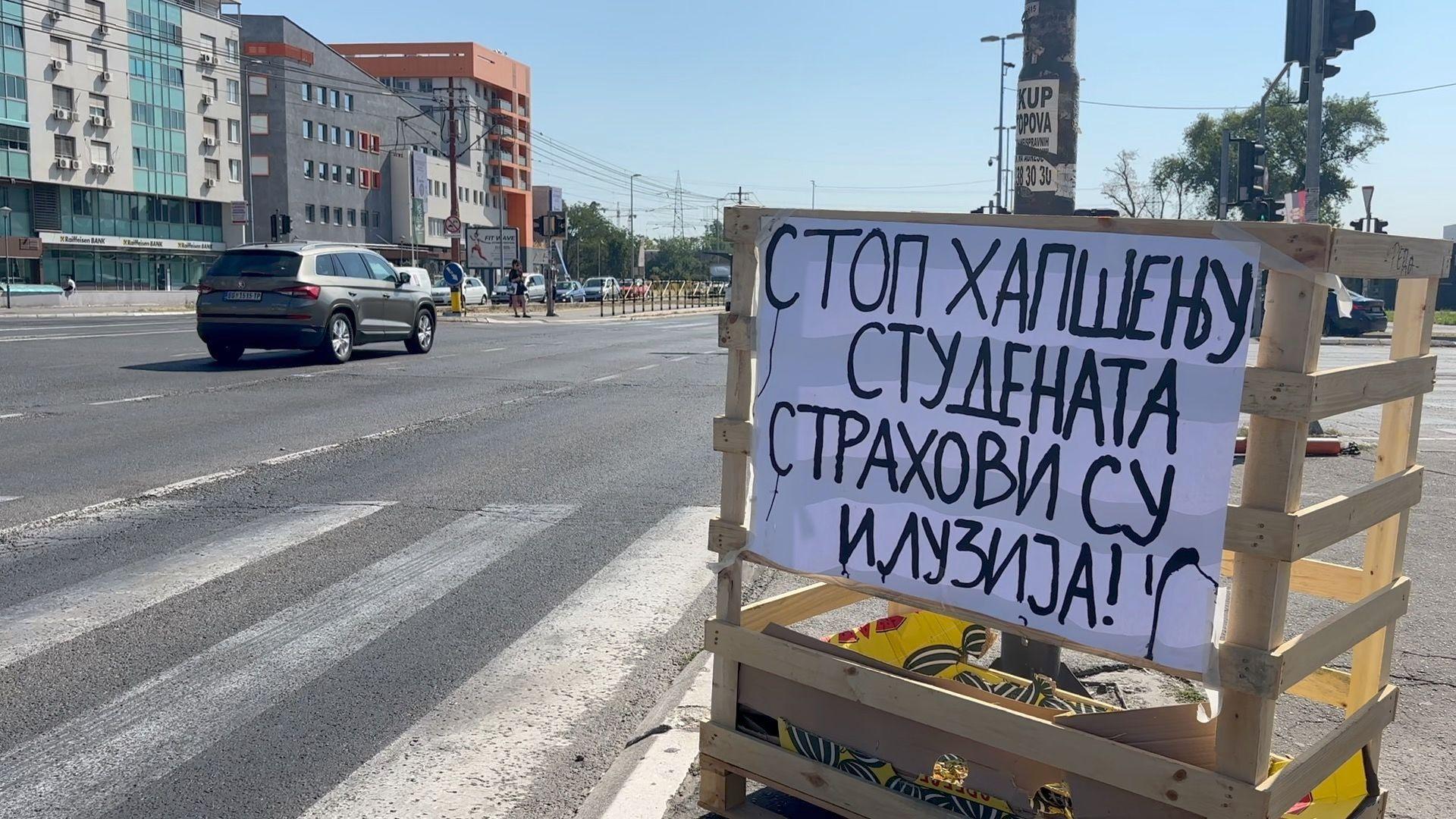 Transparent na kojem piše "Stop hapšenju studenata, strahovi su iluzija" na trotoaru pored ceste, posle blokada