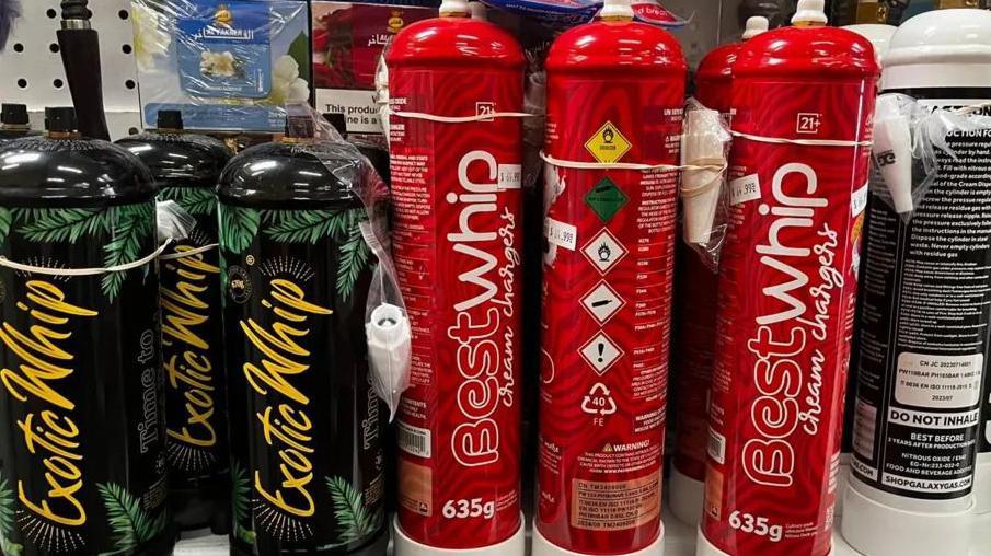 'Gas smejavac': Od smrtonosne do zakonite zavisnosti u Americi 2 Limenke azot-suboksida sa aromama u prodavnici duvanskih proizvoda blizu