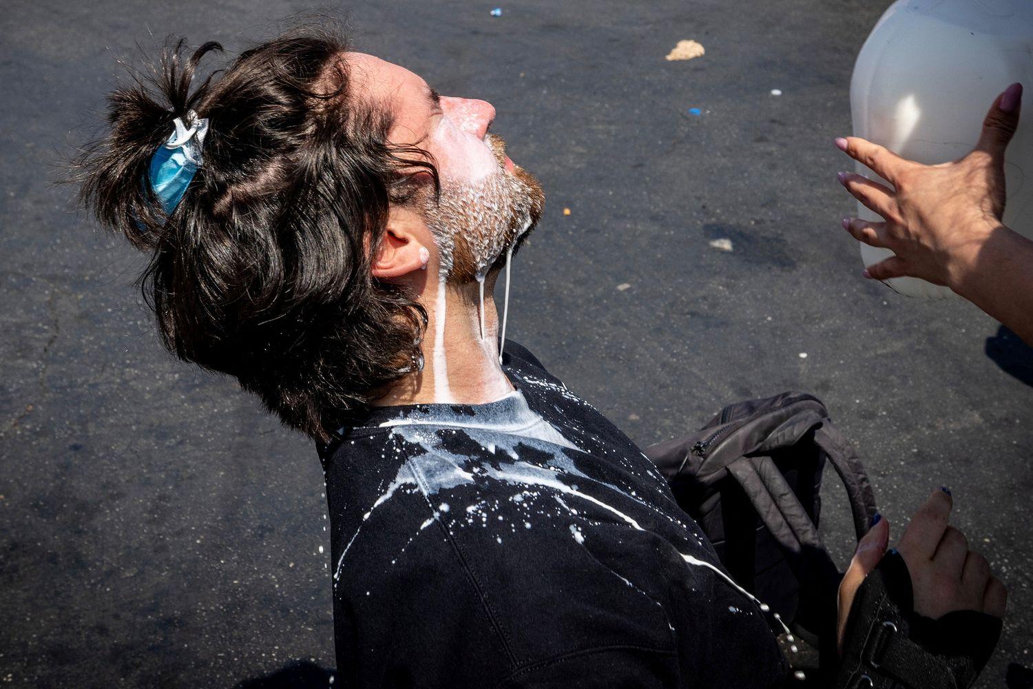 Muškarac oblivljen mlekom zbog suzavca