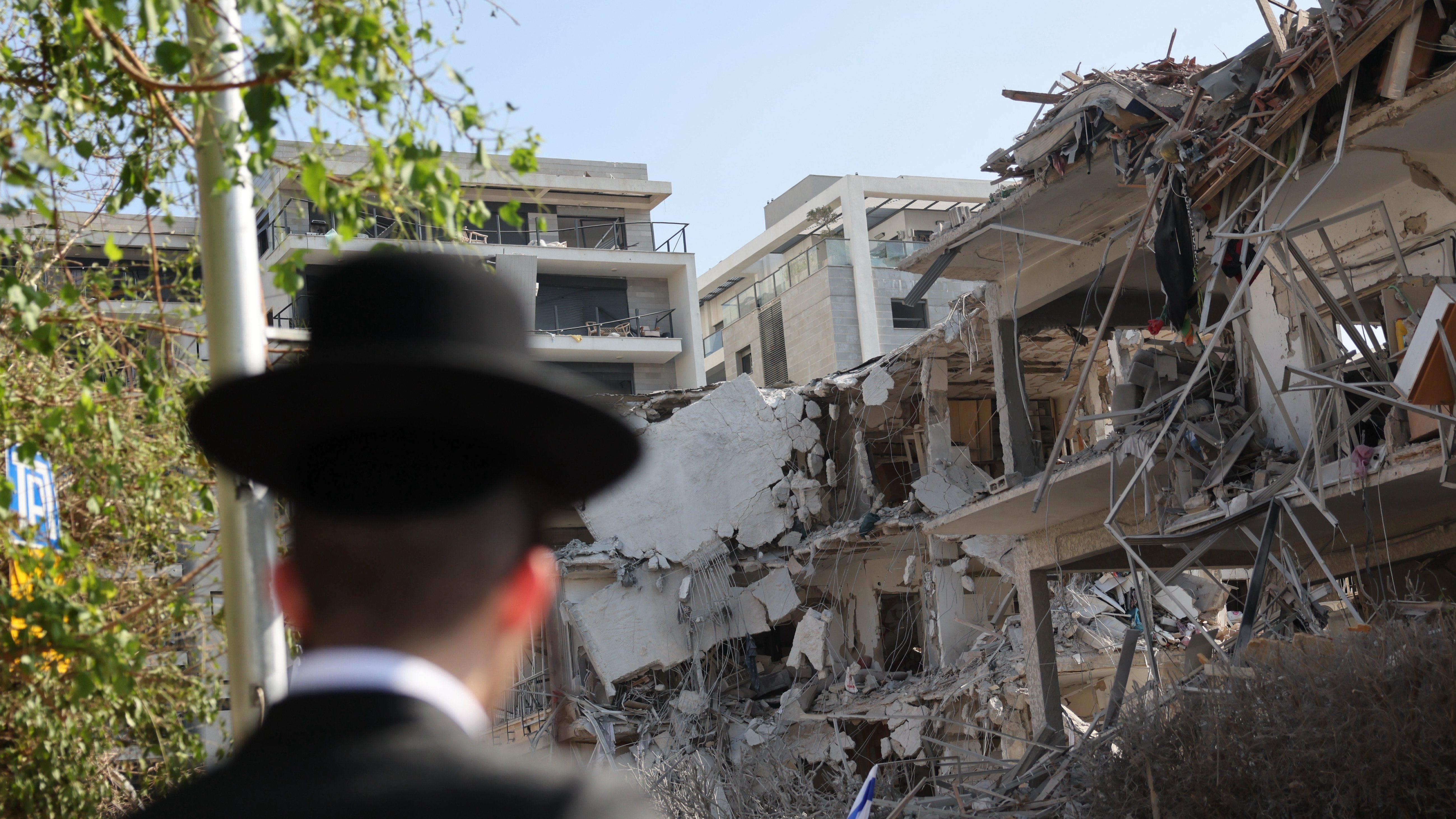 Udari Izraela i Irana: Koji su najgori mogući scenariji? 1 Srušene zgrade u Tel Avivu, muškarac sa šeširom gleda u njih