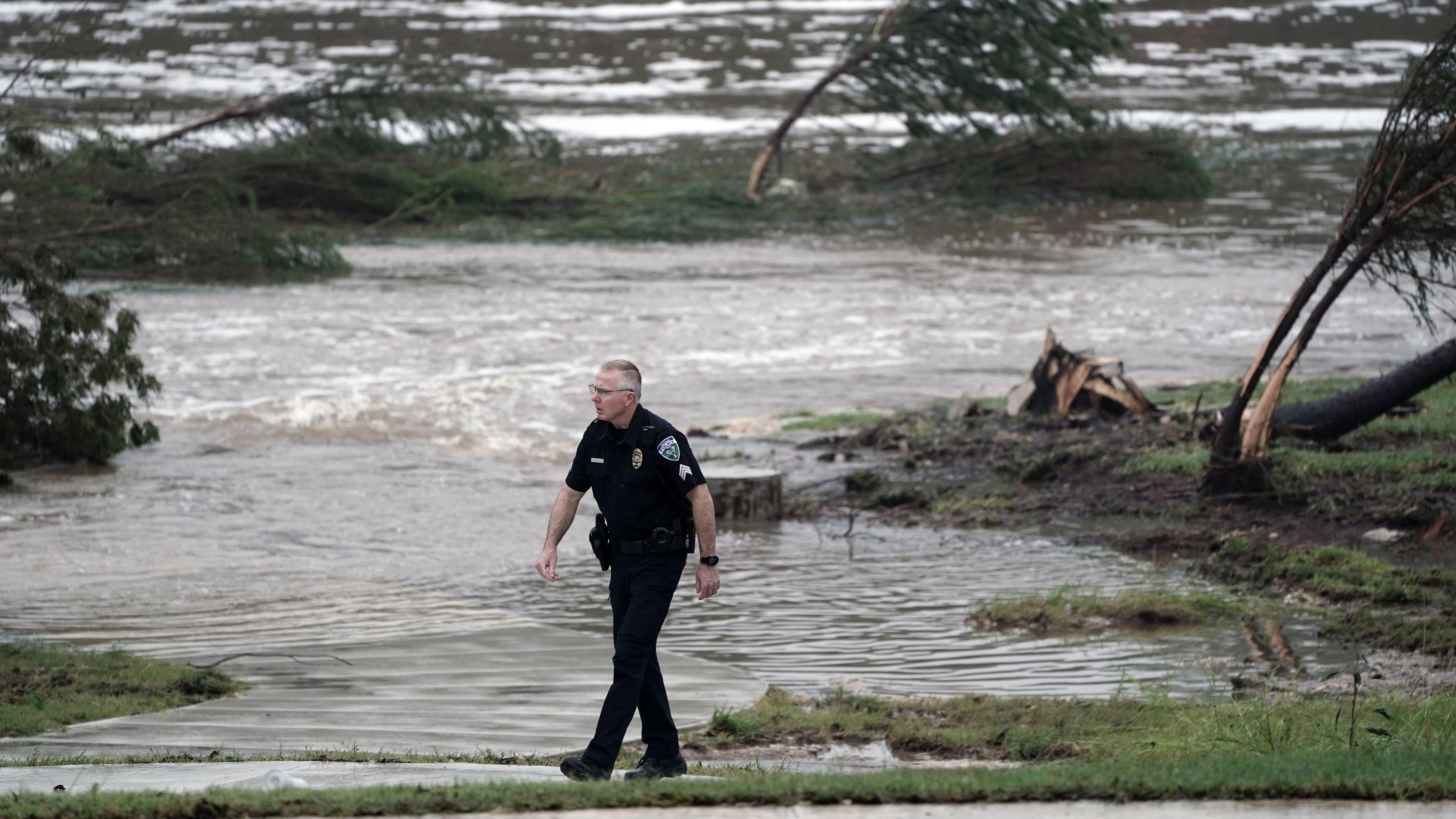 Policajac prolazi pored nabujale reke