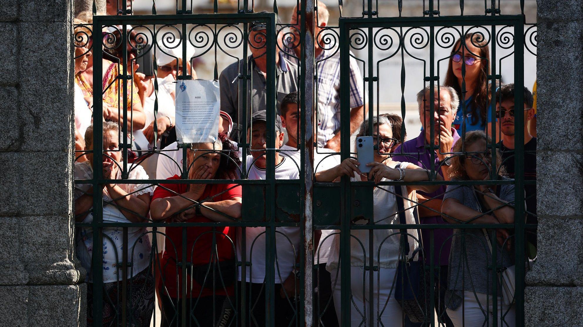 Sahranjen napadač Liverpula Diogo Žota, koji je poginuo u saobraćajnoj nesreći 6 Ljudi gledaju sahranu kroz kapiju groblja