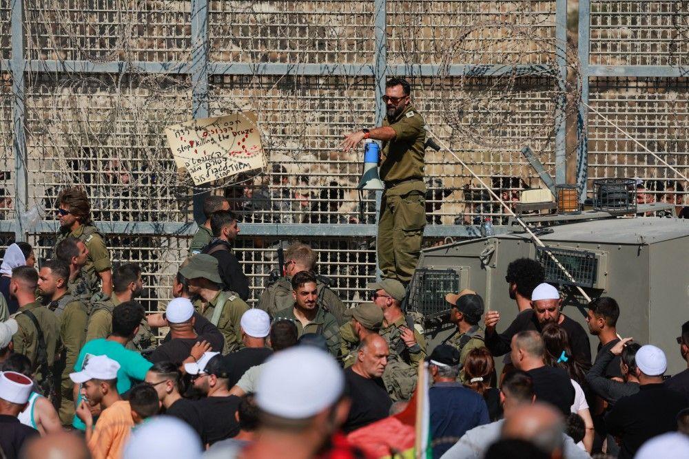 Zašto je Izrael gađao Damask i šta se dešava u Siriji 3 Izraelski vojnik drži megafon dok se izraelski Druzi okupljaju, blizu linije prekida vatre između Golanske visoravni koju je Izrael okupirao i Sirije
